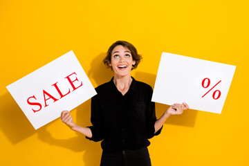 Photo of cute excited girl dressed formal shirt showing discount percent empty space copyspace cards isolated yellow color background