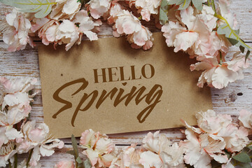 Hello Spring typography text with flowers frame on wooden background