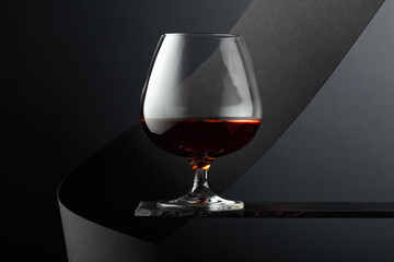 Snifter of brandy on a black background.