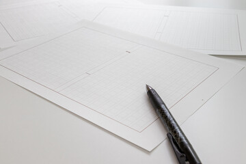 机の上の原稿用紙とボールペン