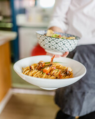 Un serveur avec deux plats dans les mains dans un restaurant
