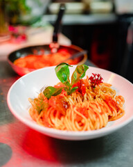 Un plat de spaghettis avec une feuille de basilic prêt à être servi dans les cuisines d'un...