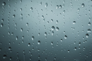 Close-up of rain drops on glass background. Premium colorful abstract background with dynamic shadow on background, consisting of water on glass, gradient color, artistic texture, epic, beautiful