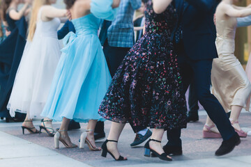 High school graduates dancing waltz and classical ball dance in dresses and suits on school prom...