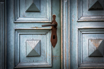 close-up of an old wooden door with rusty door handle