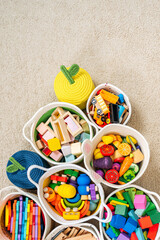 Colorful Toy Storage Baskets in the children's room. Cloth stylish Baskets with wooden toys. Organizing and Storage Ideas in nursery. Clean up toys and reduce the clutter. Top view