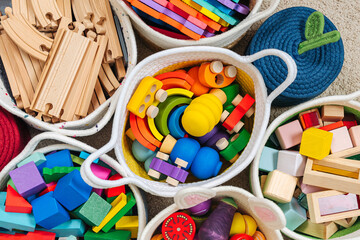 Colorful Toy Storage Baskets in the children's room. Cloth stylish Baskets with wooden toys....