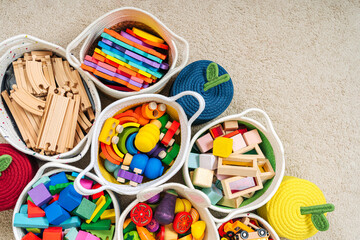 Colorful Toy Storage Baskets in the children's room. Cloth stylish Baskets with wooden toys....