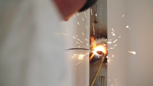 man welds pipes by gas welding