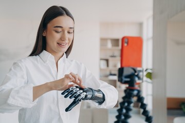 Blogger disabled girl shows bionic prosthetic arm live streaming in social networks using smartphone