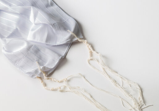 Jewish national and religious tallith katan - in the form of a cape with brushes. Theme of traditions, jewish ritual object. Jewish holiday of Sukkot, shabbat, rosh hashanah. Tallit katan, background