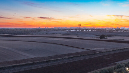 Tramonto sui terreni agricoli coltivati, sfondo industrie