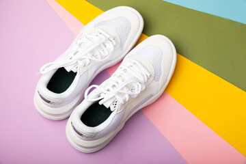 White sneakers on a colored background.Fashion.UNISEX. Sneakers are sports shoes for an active lifestyle. Product photo and levitation concept. Street style. Copy space. Place for text.