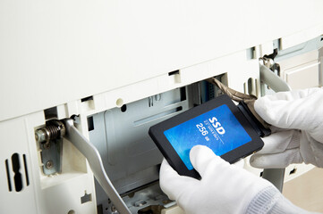 2.5 inch ssd hard drive that technician is installing in computer