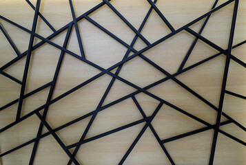 Welded square black iron pipes on a wood panel of reception desk  