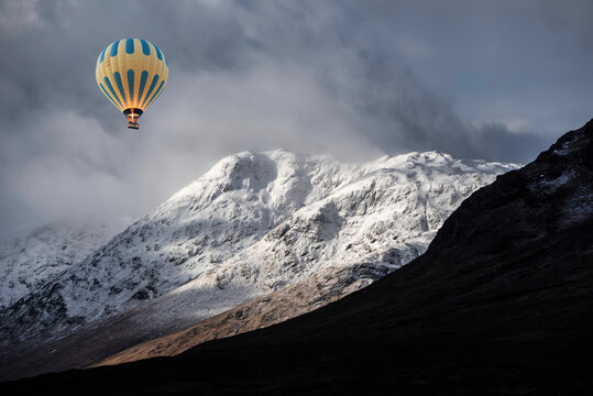 Digital composite image of hot air balloons flying over Majestic beautiful Winter landscape image of Lost Valley in Scotland with snowcapped Buachaile Etive Baeg