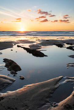 Stunning Summer sunset landscape image of Widemouth Bay in Devon England with golden hour light on beach