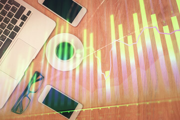 Double exposure of forex chart hologram over desktop with phone. Top view. Mobile trade platform concept.