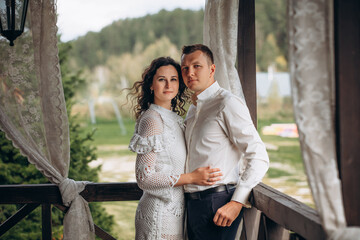Naklejka premium Beautiful happy couple in love man and woman, portrait on the terrace of the house