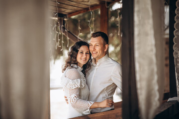 Beautiful happy couple in love man and woman, portrait on the terrace of the house
