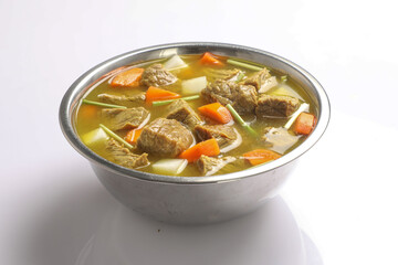 Beef with carrots, onions various fresh vegetables in a pot - colorful fresh clear spring soup. Rural kitchen scenery vegetarian stock