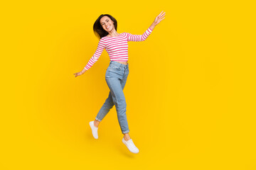 Full size photo of adorable lovely girlish woman dressed striped long sleeve jeans jumping flying...
