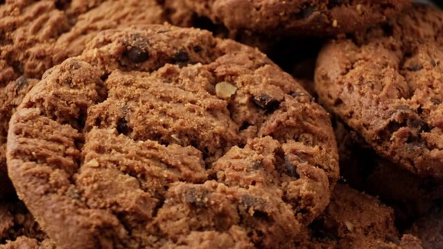 Fresh oatmeal cookies rotating. Pile of whole meal cookies. Food concept. Homemade cookies with chocolate. Close-up in 4K, UHD