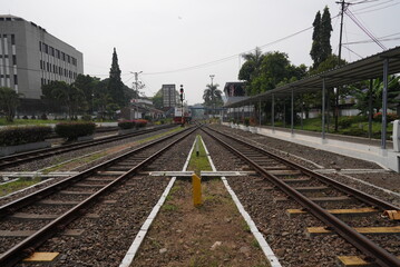 Fototapeta na wymiar Rocky train rail in near the train station at noon with cityscape 