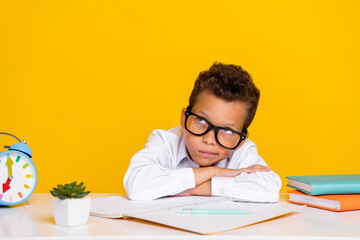 Photo of smart minded boy look interested empty space contemplate isolated on yellow color background