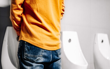 back Man peeing to toilet bowl in restroom