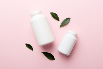supplement pills with medicine bottle health care and medical top view. Vitamin tablets. Top view mockup bottle for pills and vitamins with green leaves, natural organic bio supplement, copy space