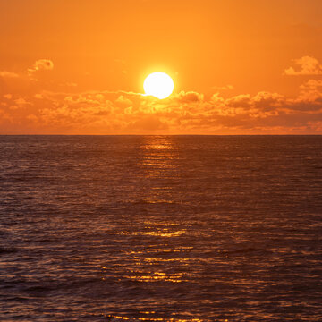 Sun Rising Above Calm Ocean