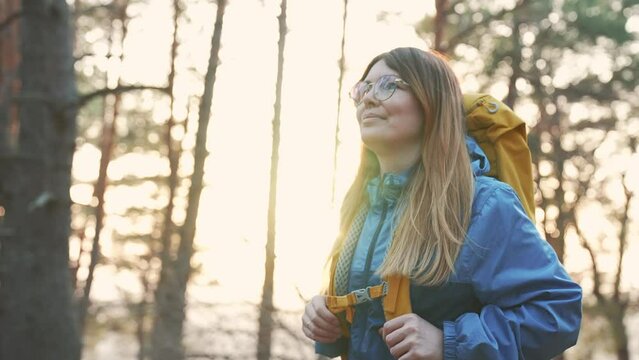 Girl travels through the natural park on foot. Hiking in woods. Girl tourist hike with backpack. Summer adventure, vacation freedom. Woman travels outdoors with a backpack. Hiking in the mountains