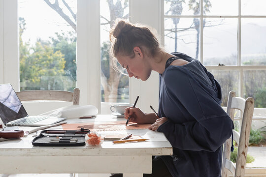 Teenage girl (16-17) drawing at home