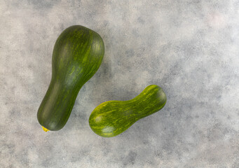 Raw zucchini on a light gray table. Top view, copy space