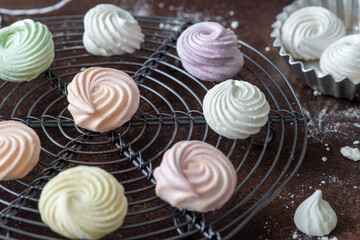meringue cookies on cake rack, sweet food for dessert, dark background