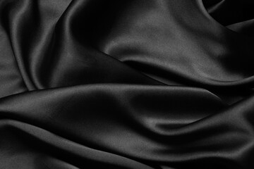 Black fabric texture background, wavy fabric slippery black color, luxury satin cloth texture.