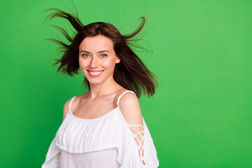 Fototapeta premium Portrait of gorgeous positive lady beaming smile flying hair empty space isolated on green color background