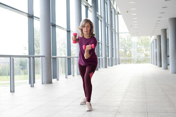 Mature woman in sports clothing stretching , Staying fit is one way to age with grace