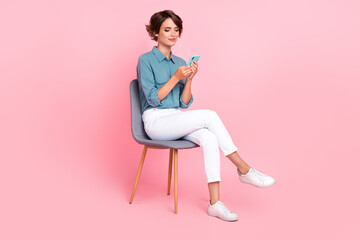 Photo of satisfied lady wear trendy outfit sit chair relax texting telegram facebook instagram write post isolated on pink color background