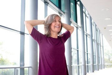 Mature woman in sports clothing stretching , Staying fit is one way to age with grace