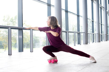 Mature woman in sports clothing stretching , Staying fit is one way to age with grace