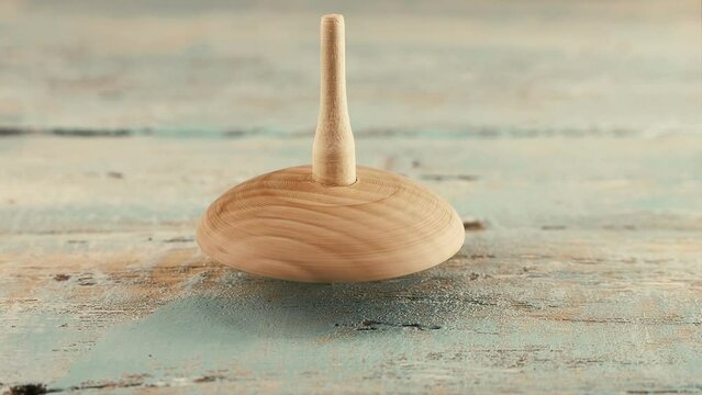 Peg toy or whirligig rotates on a vintage wooden board.