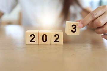 Naklejka premium hand arrange a wooden dice for 2023 year to start and change to new years.