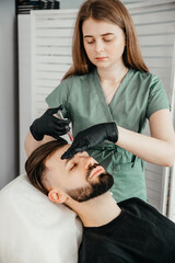 Fototapeta premium Mesotherapy. Injections with vitamins for hair growth on bald parts of the head in a young man