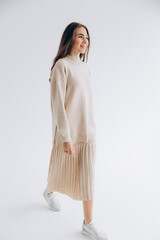 29.04.22 Kyiv, Ukraine: stylish portrait of a young woman posing for a photo on a white background studio cyclora with natural daylight from the window