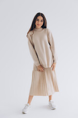 29.04.22 Kyiv, Ukraine: stylish portrait of a young woman posing for a photo on a white background studio cyclora with natural daylight from the window