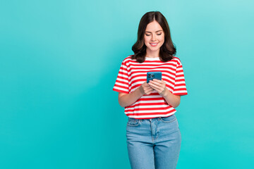 Fototapeta na wymiar Photo of pretty shiny lady wear striped t-shirt browsing twitter facebook telegram modern device empty space isolated turquoise color background