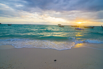 Sunset sea wave beach with wooden fishery boat