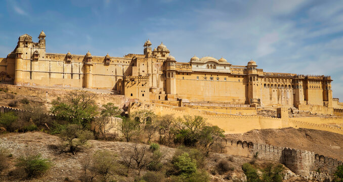 Amber Fort illuminated by warm light of the rising sun and reflected in the lake. Famous Rajasthan landmark